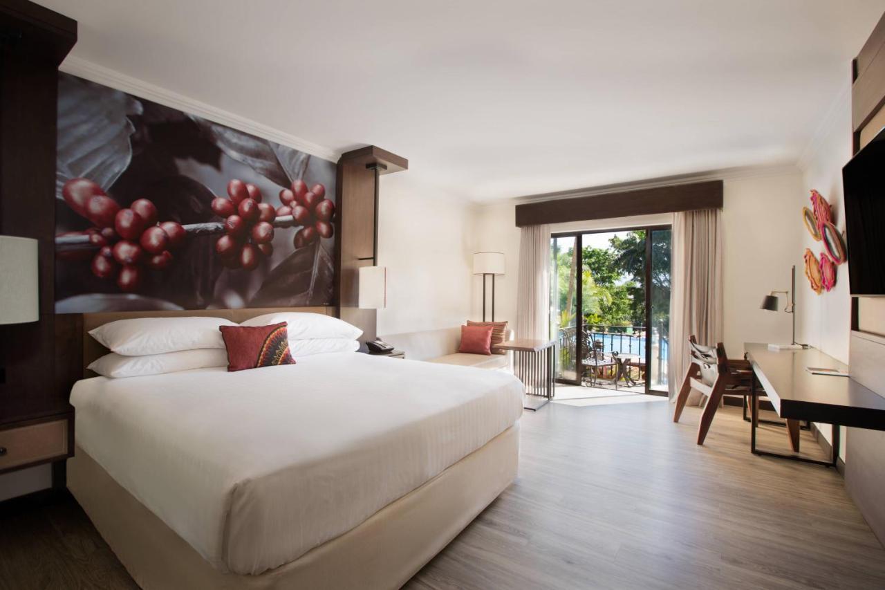 Zimmer im Erdgeschoss mit Kingsize-Bett und Poolblick
