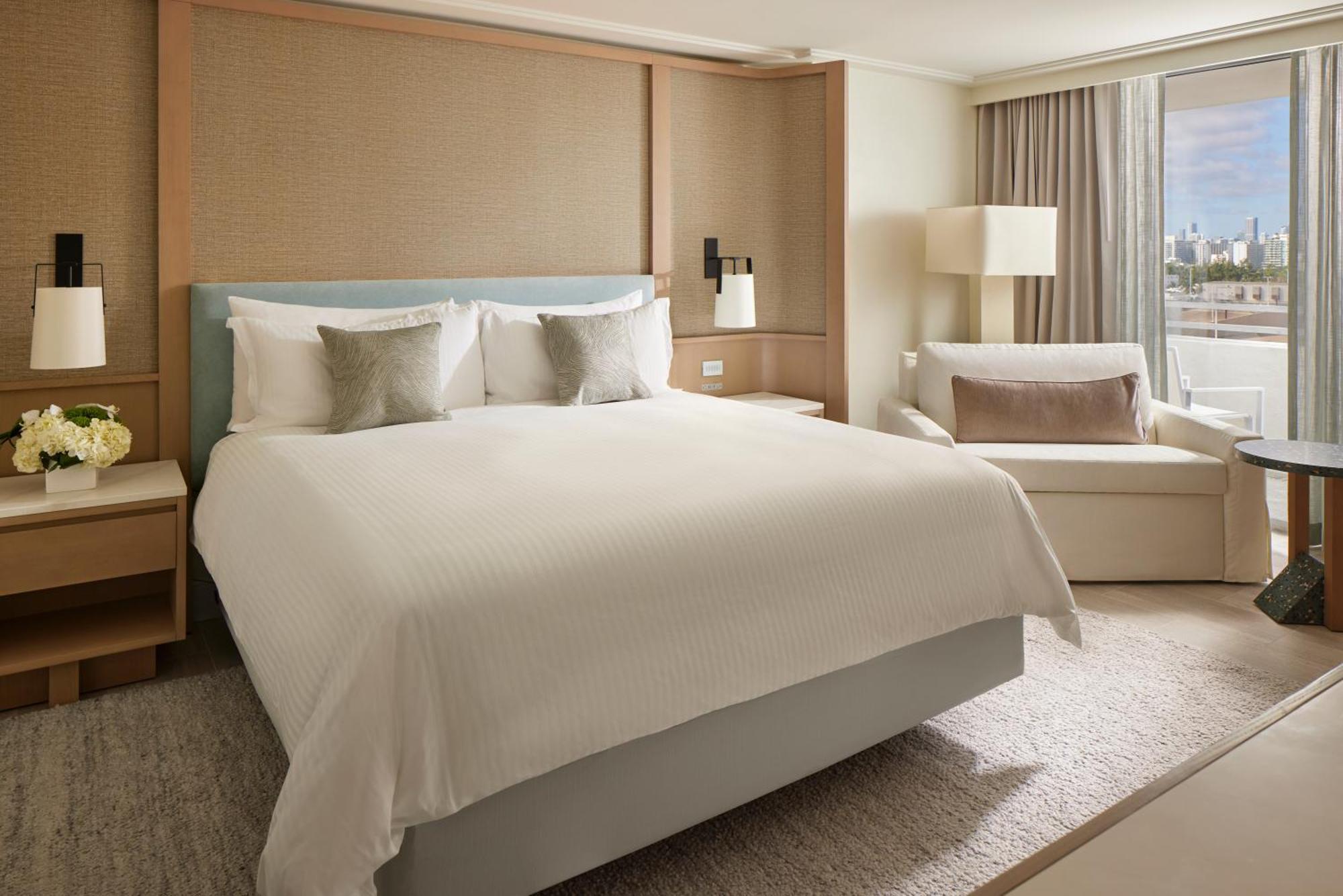 Zimmer mit Kingsize-Bett und Blick auf die Skyline der Stadt